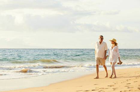 Couple walking hand in hand on the beach