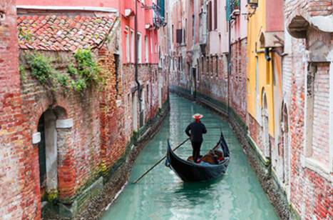 Venetian gondolier punting through Venice