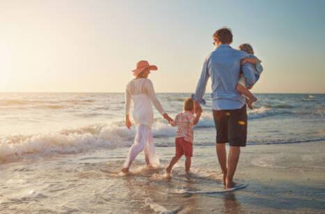 Image of family walking along the beach on their summer holiday