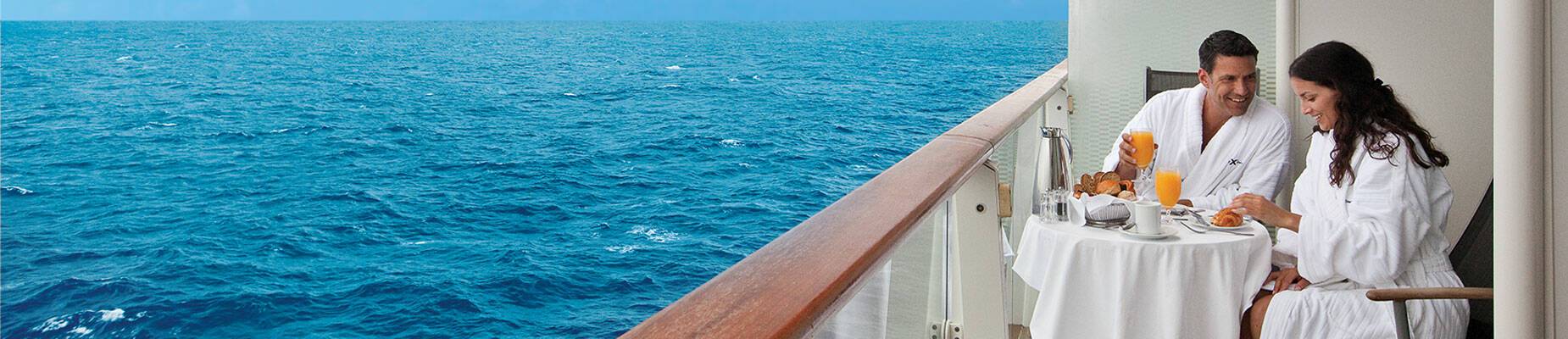 A couple sitting on the veranda of a cruise ship
