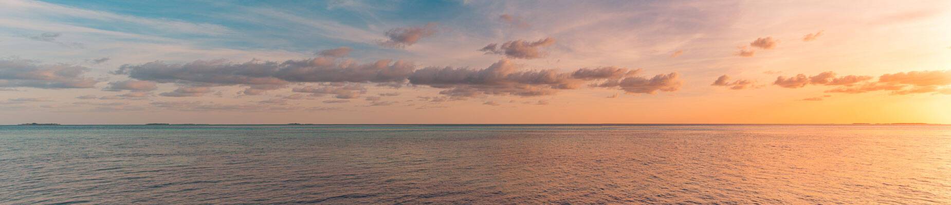Panoramic image of the sun setting over the horizon