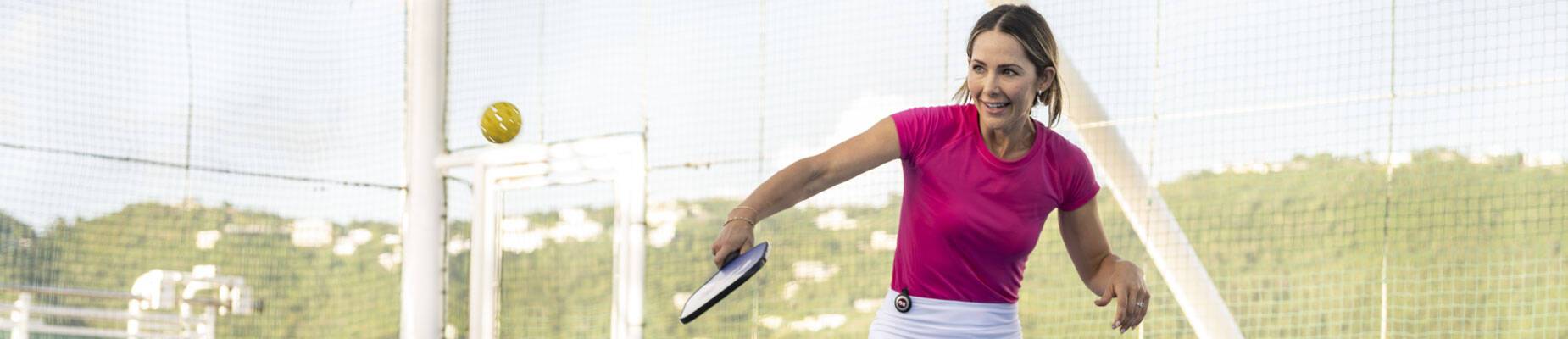 A happy woman playing pickleball on Princess Cruises' Enchanted Princess