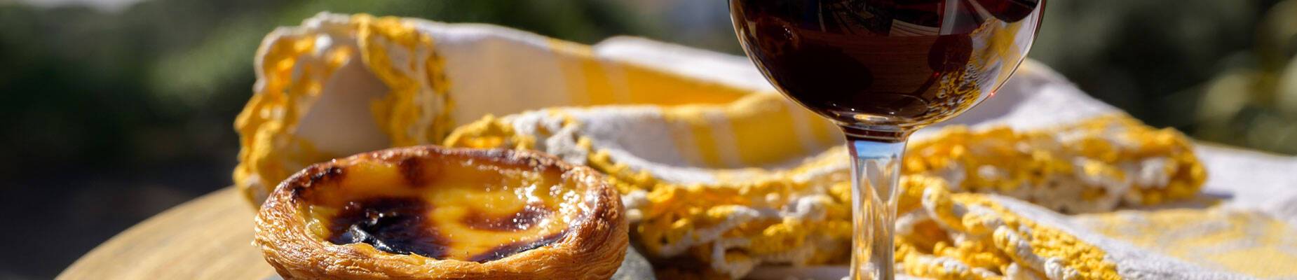 A glass of porto wine and sweet dessert Pastel de Nata
