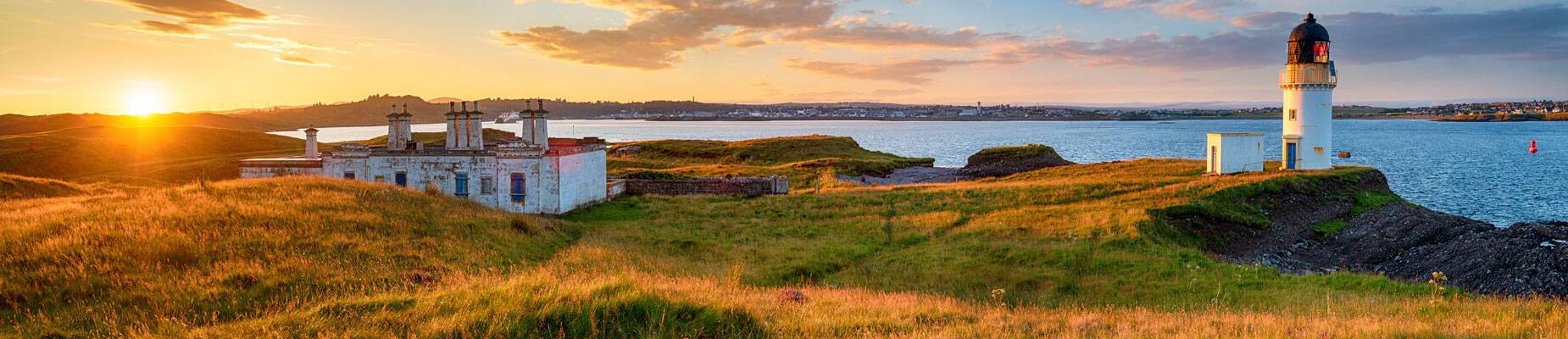 A panoramic image of the sunset over Arnish Point in Stornoway harbour on the Isle of Lewis in Scotland
