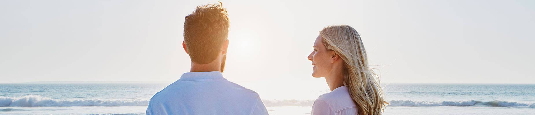 A couple on the beach looking out at sea