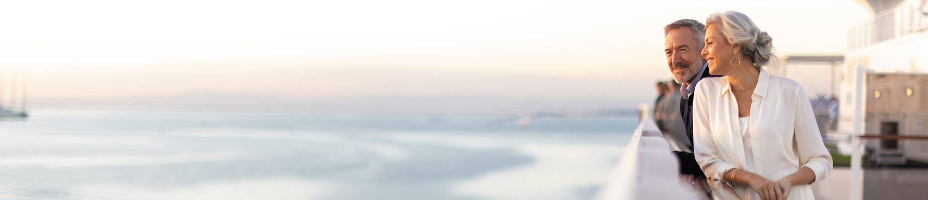 A couple standing on the pool deck of Seven Seas Grandeur
