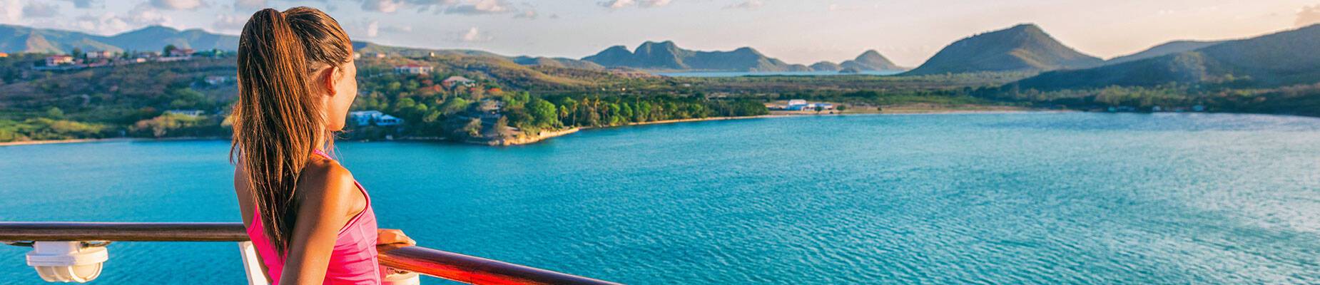 A girl looking out over sea from the top deck of a cruise ship