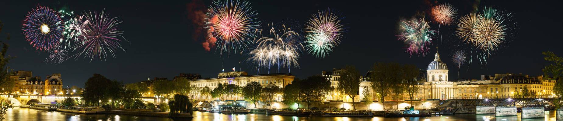 Panoramic image of riverside in Paris with New Year’s fireworks