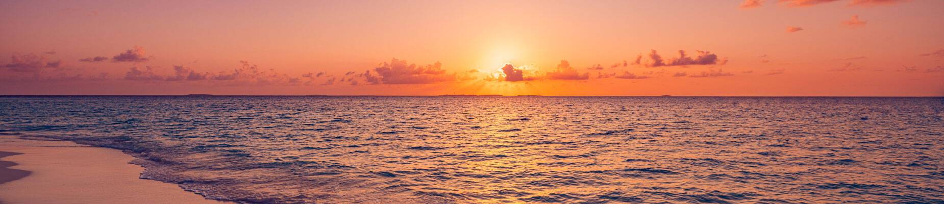 Panoramic image of the sun setting over the sea