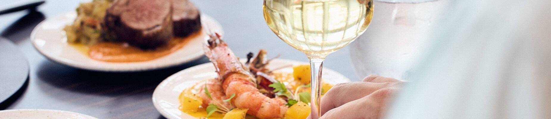 A table laden with food from the perspective of the diner