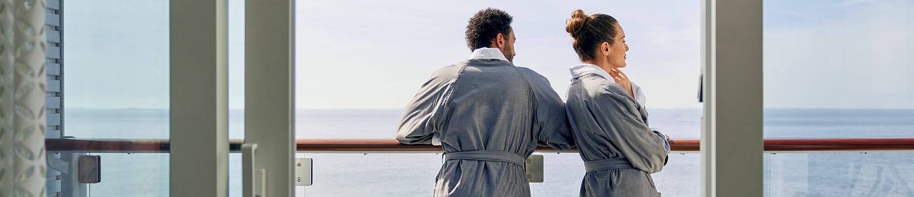 A couple standing on the balcony of a cruise ship
