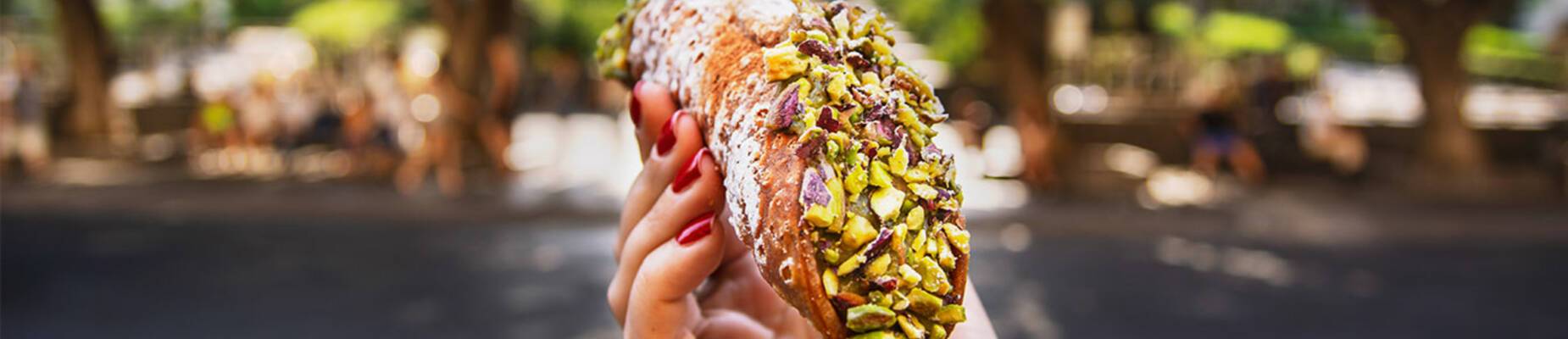 Hand holding a pistachio cannoli