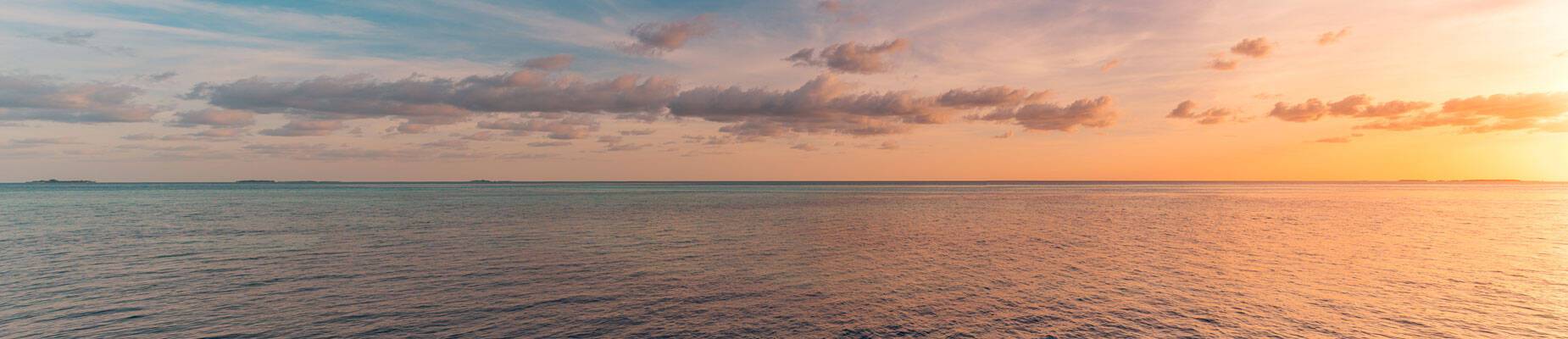 Panoramic image of the sun setting over the horizon