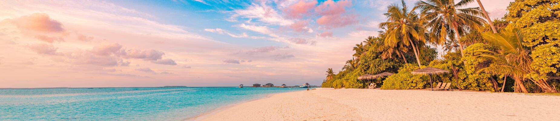 A panoramic image of a Caribbean beach at sunset