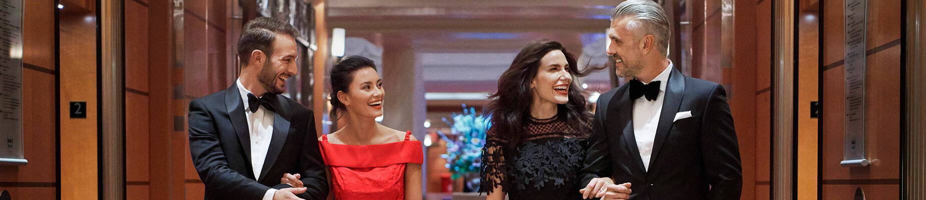 Four people walking along a cruise ship corridor